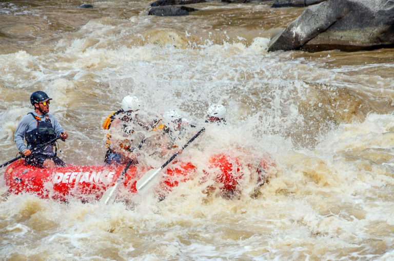 A raft hits a rapid while Colorado river rafting